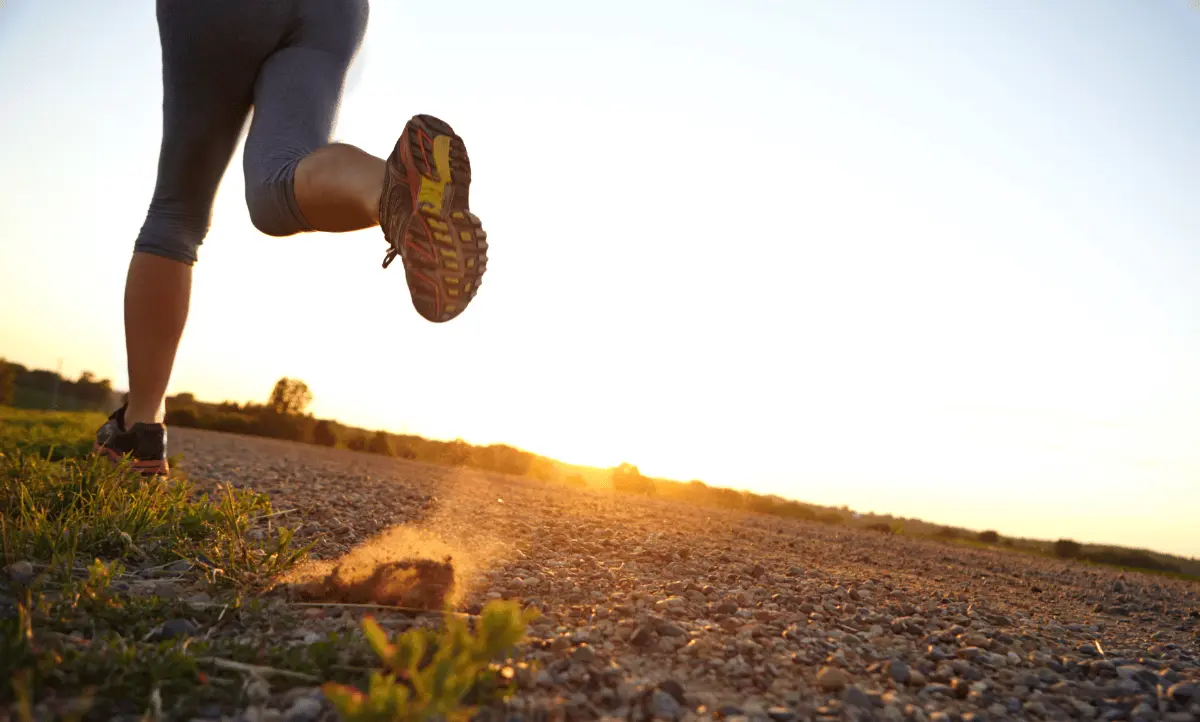 Een persoon die hardloopt tijdens zonsopgang, symbool voor het belang van fysieke activiteit in een productief leven.