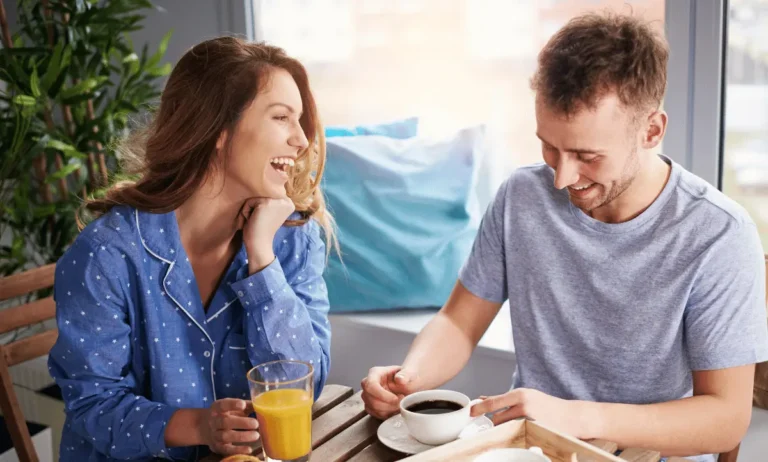 Man en vrouw lachen tijdens een ontspannen ontbijt
